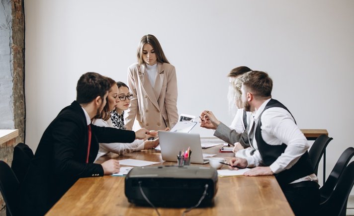 Discuss. Speaker giving presentation in hall at university workshop. Audience or conference hall. Participants, co-workers listening at the table. Scientific, business event, training. Education